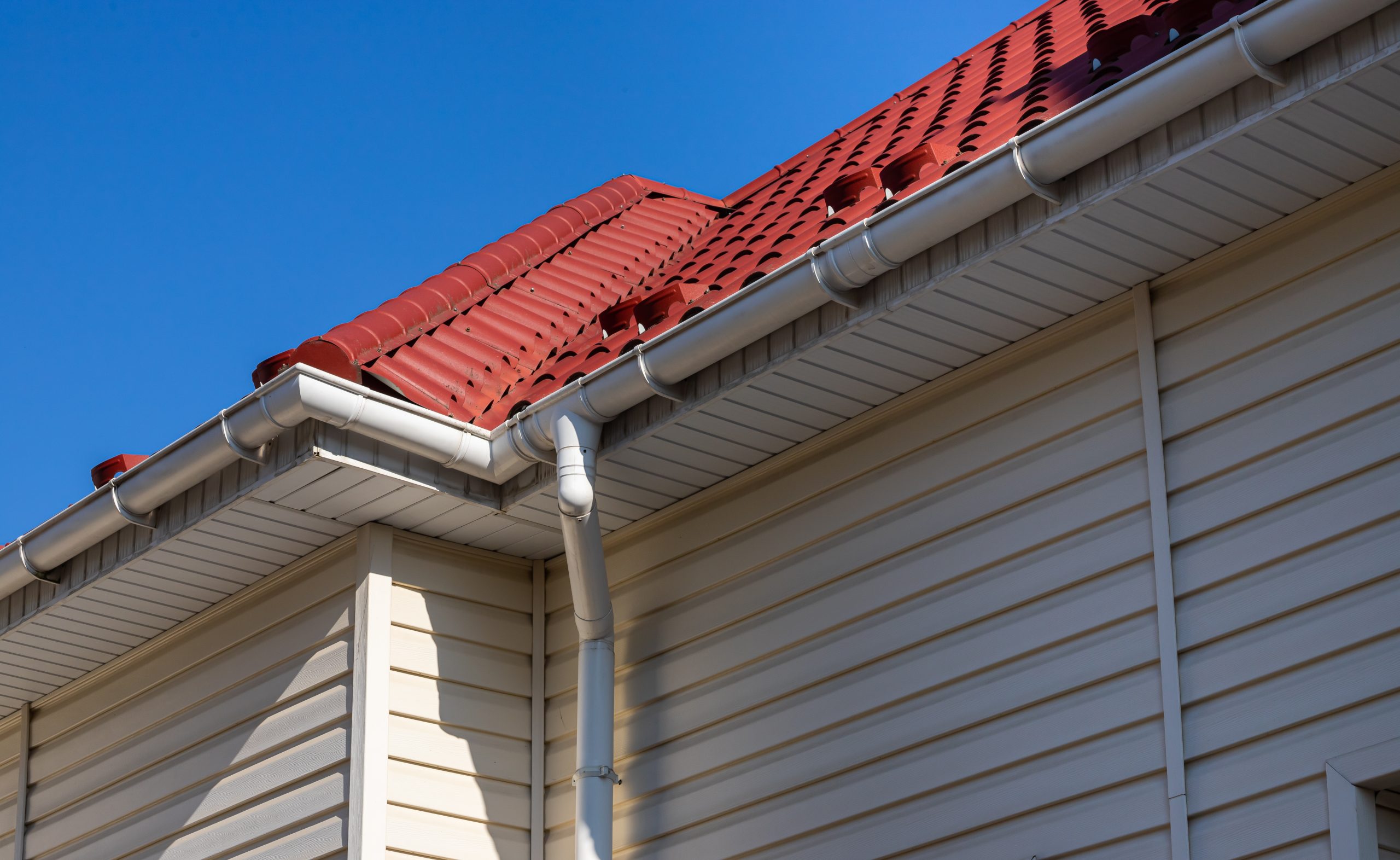 Building Modern House Construction with metal roof corner, rain gutter system and roof protection from snow board, snow bar Snow guard. Roof Snow Guards: Building Materials Supplies